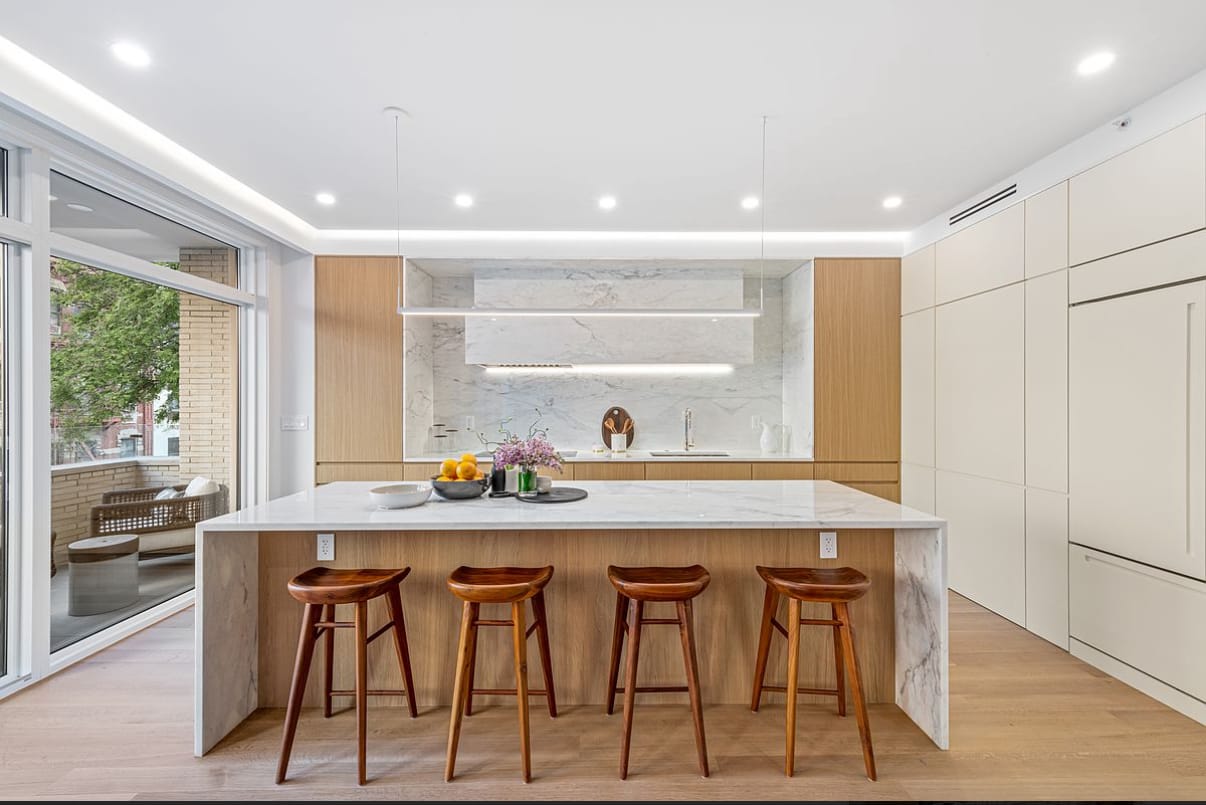 Modern kitchen island with wood bar stools and marble waterfall edge