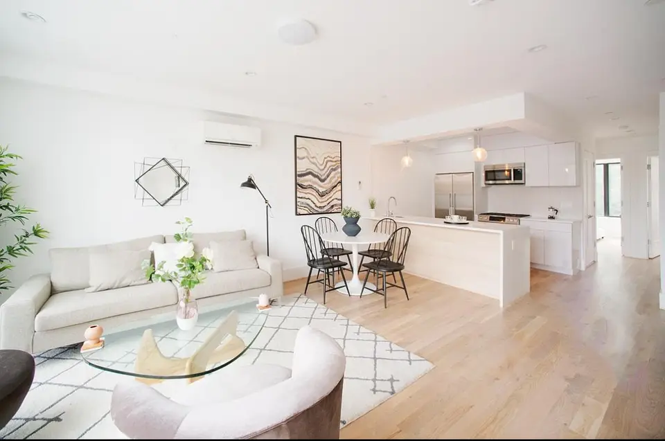 Bright modern white kitchen with open concept dining and living area