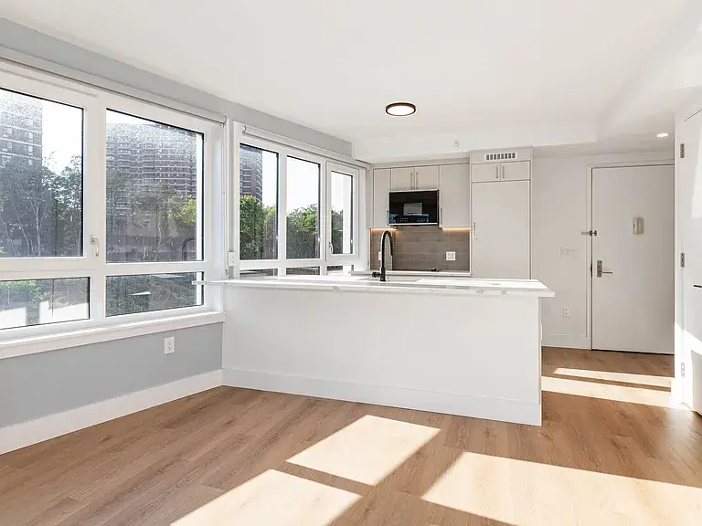 Bright white kitchen with island and floor-to-ceiling windows