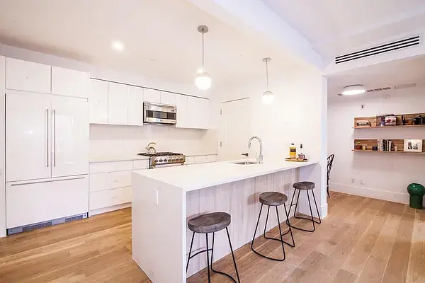 Contemporary white kitchen with wood island and bar seating