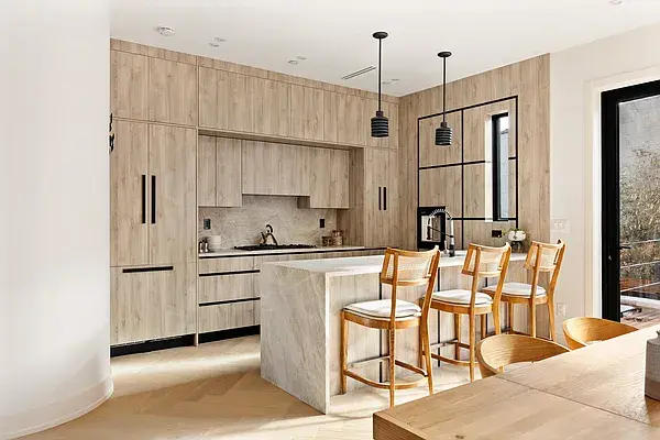 Light wood kitchen with marble island and bar seating