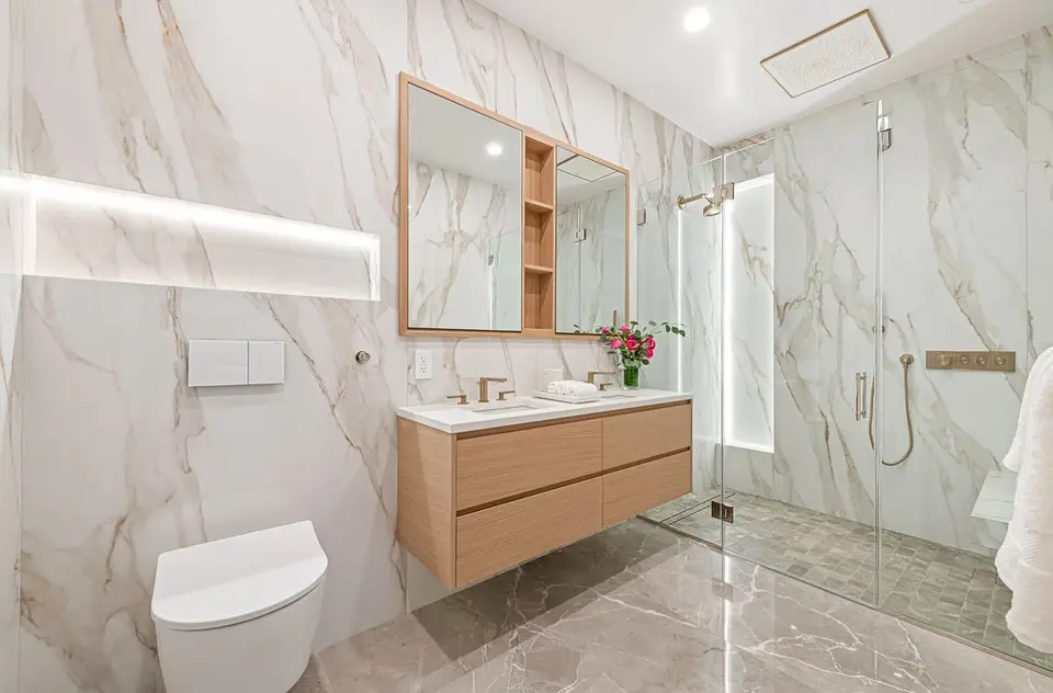Luxury marble bathroom with wood vanity and walk-in glass shower