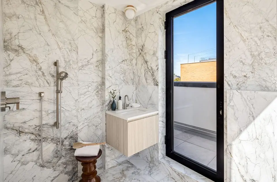 Luxury marble bathroom with wood vanity and outdoor access