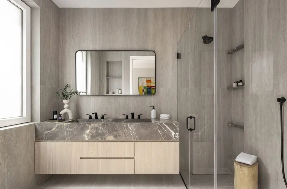 Modern bathroom with floating wood cabinets and marble vanity
