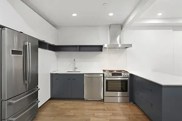 Modern gray and white L-shaped kitchen with stainless steel appliances