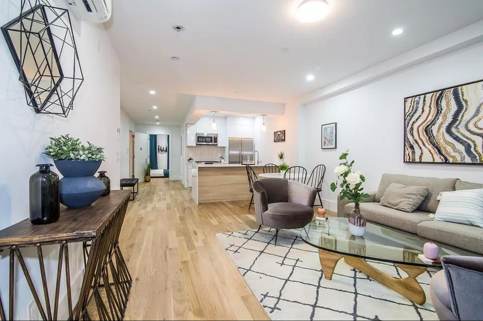 Modern open concept living area with wood kitchen and pendant lighting