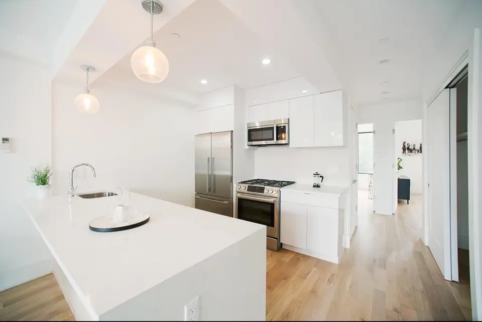 Modern white kitchen with island and globe pendant lights