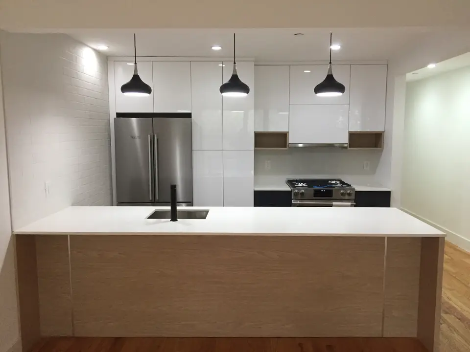 Modern white kitchen with wood island and pendant lights