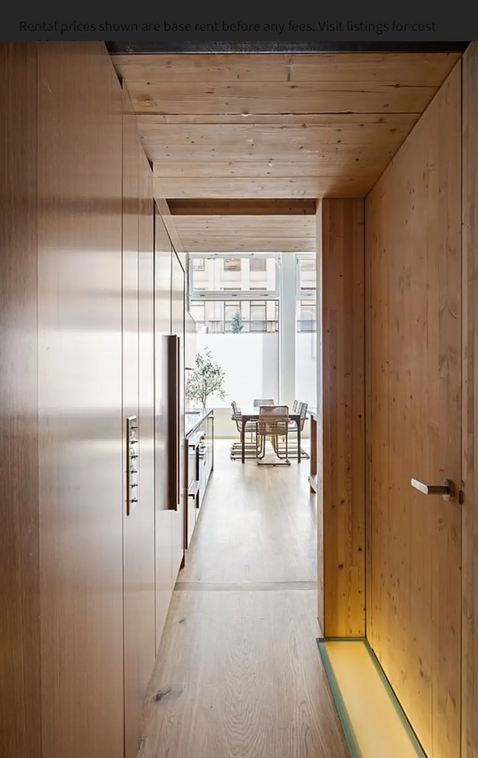 Natural wood hallway with built-in storage cabinets and ceiling panels