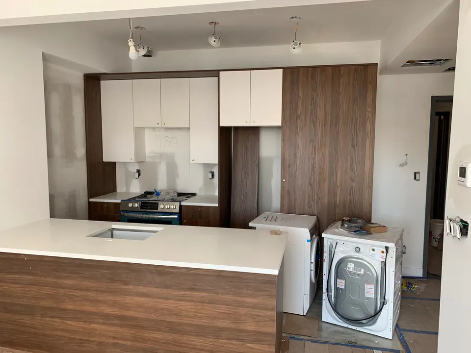 Two-tone kitchen construction with wood island and white cabinets