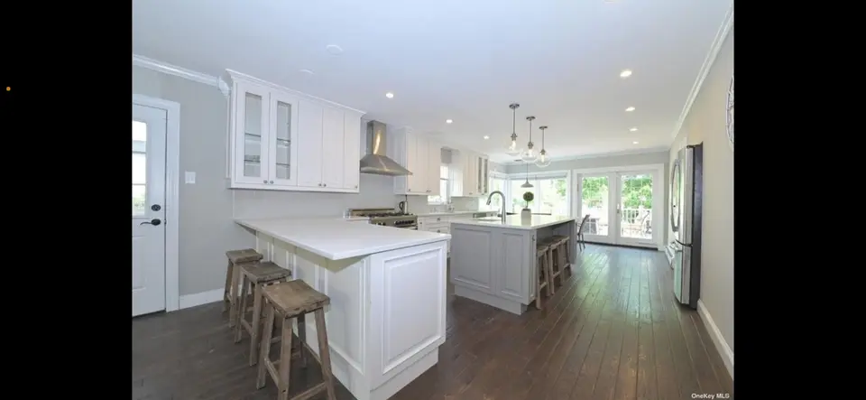White kitchen with dual islands and glass globe pendant lights