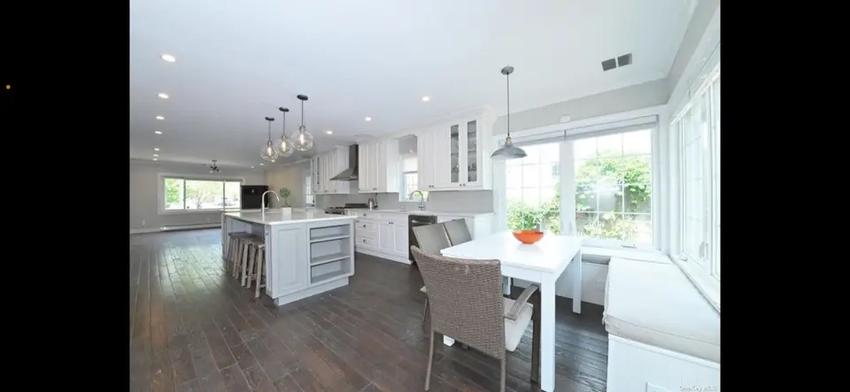 White kitchen island with adjacent dining nook and built-in seating