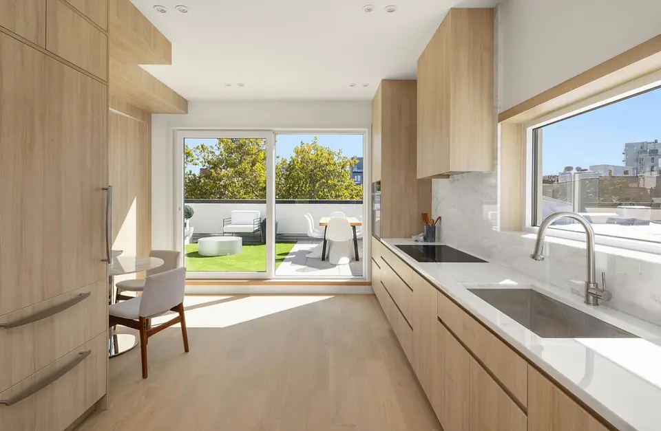 Wood kitchen with marble countertops and outdoor patio access